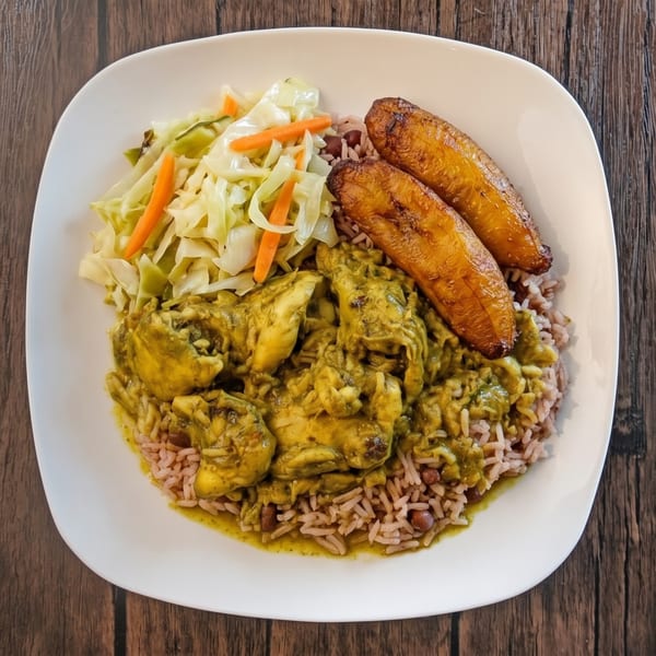 Curry chicken with rice and peas, fried plantains, and steamed cabbage on a white plate.